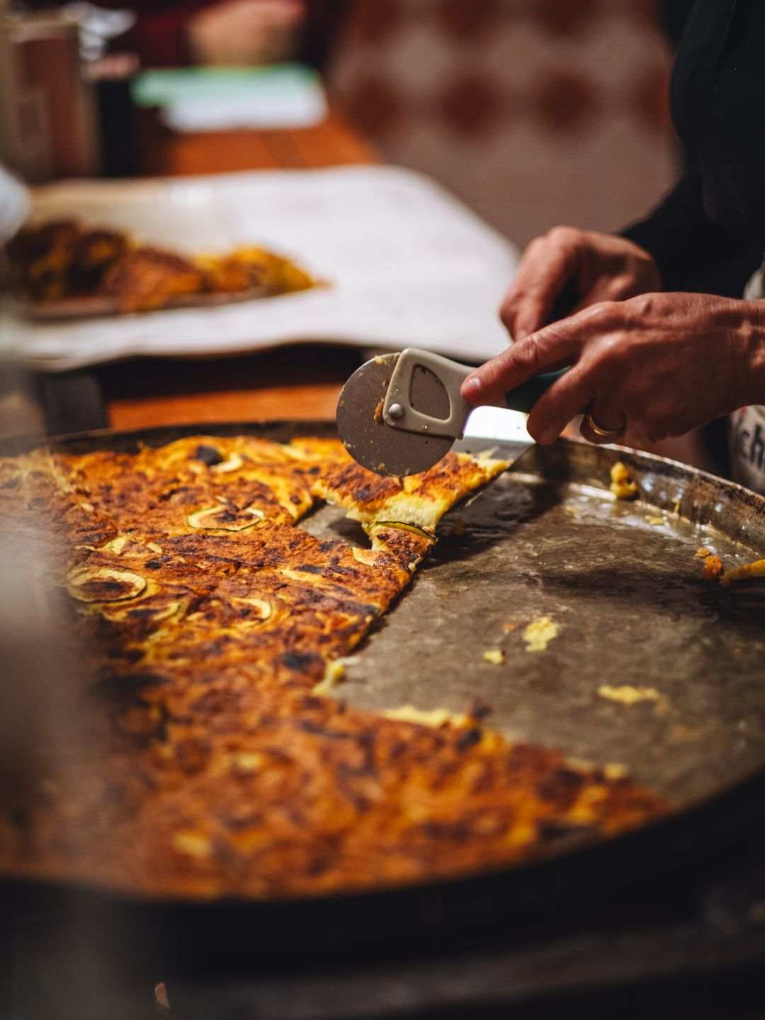 Fainè sassarese appena sfornata, tagliata a fette con la rotella