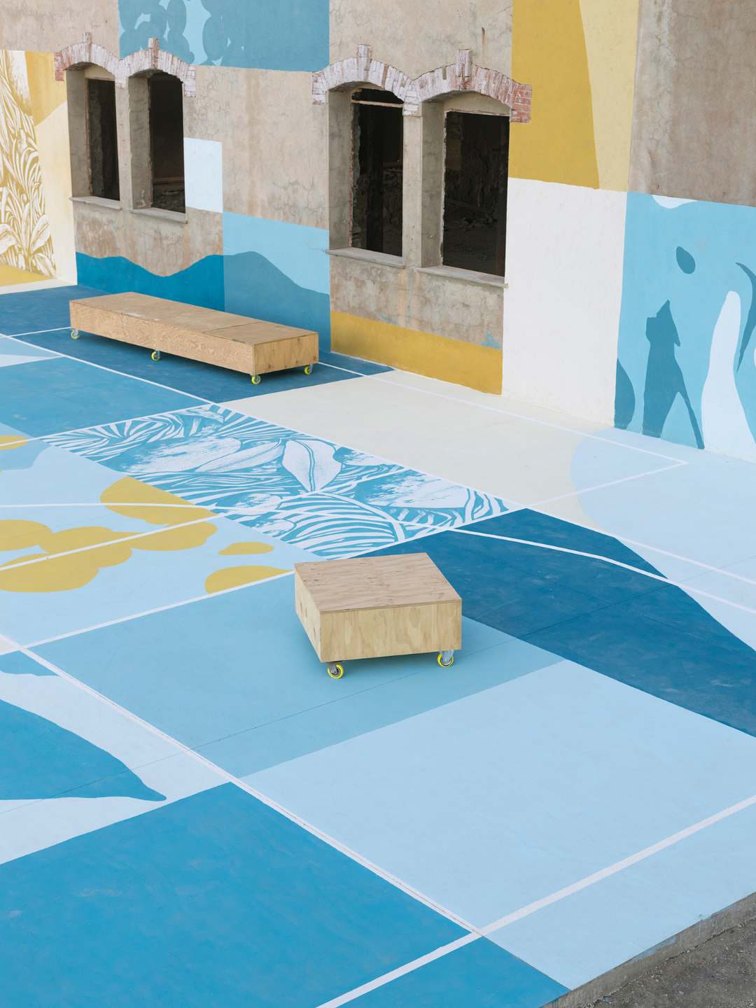 Fronte Mare all'Argentiera con pavimentazione geometrica blu e gialla e arredi in legno